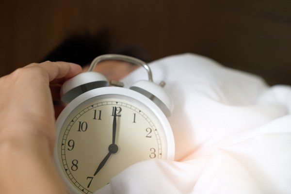 Person holding an alarm clock